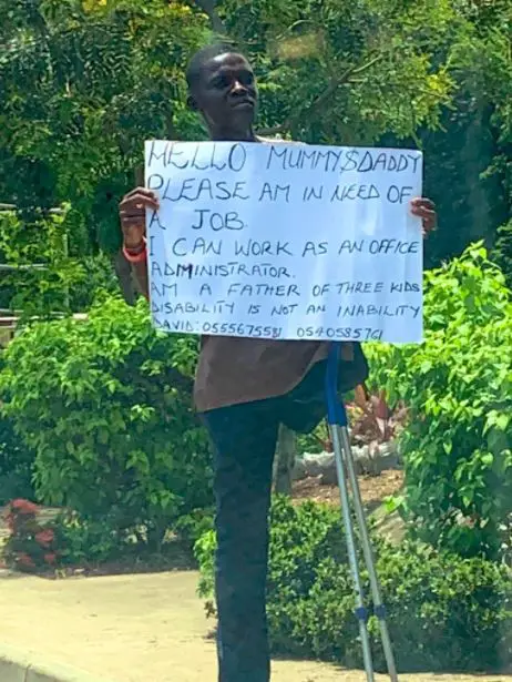 Young man with disability storms the street with placard to search of job